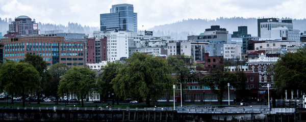 Portland waterfront with trees and buildings with mountains in the distance